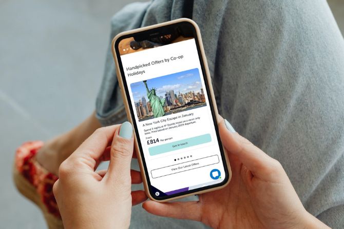 A person holding a mobile of a Coop Travel website